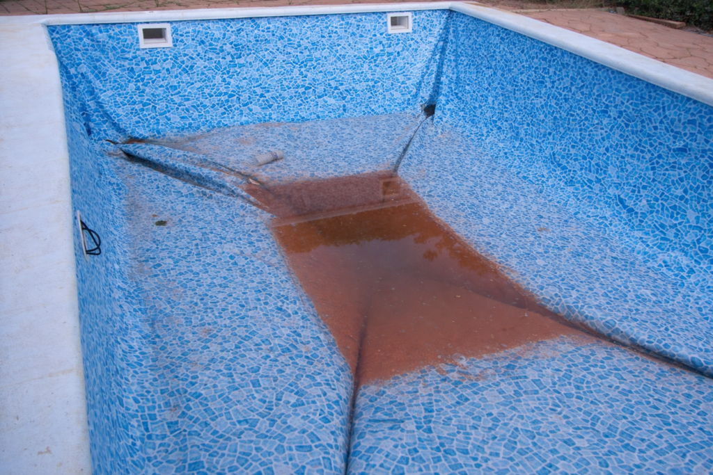 liner de piscina deteriorado con acumulacion de agua por posible fuga